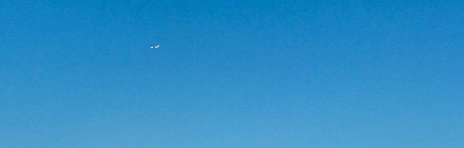 快晴の空を飛ぶ飛行機