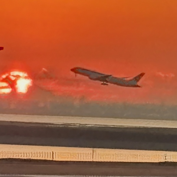 朝焼けの空に離陸する飛行機
