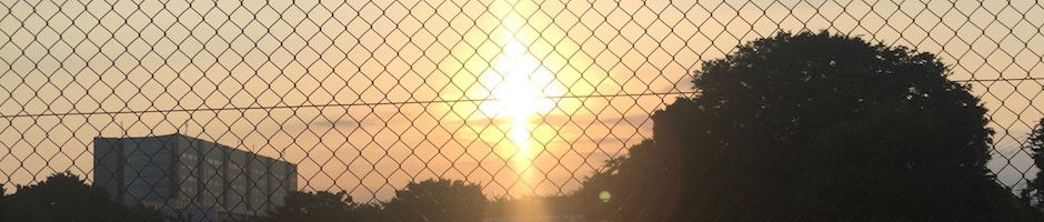 フェンスの向こうに沈む夕日